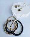 Black Camellia necklace in gold on mama card